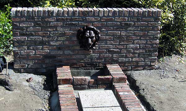 tuinmuur met spuitmond en gemetselde opvangbak